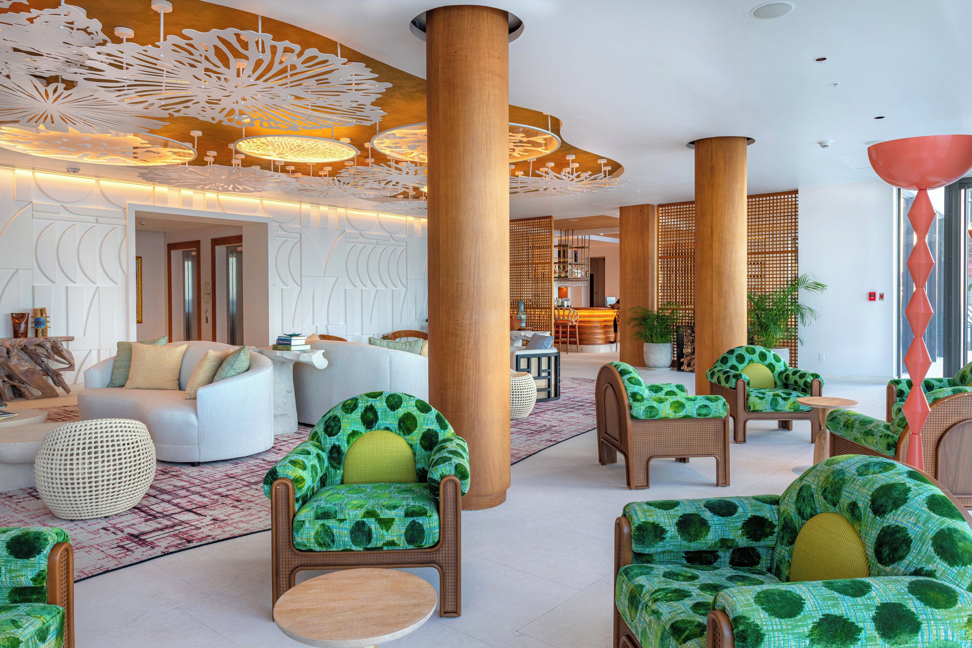 A spacious lobby with modern furniture, large wooden columns, and decorative ceiling lights.