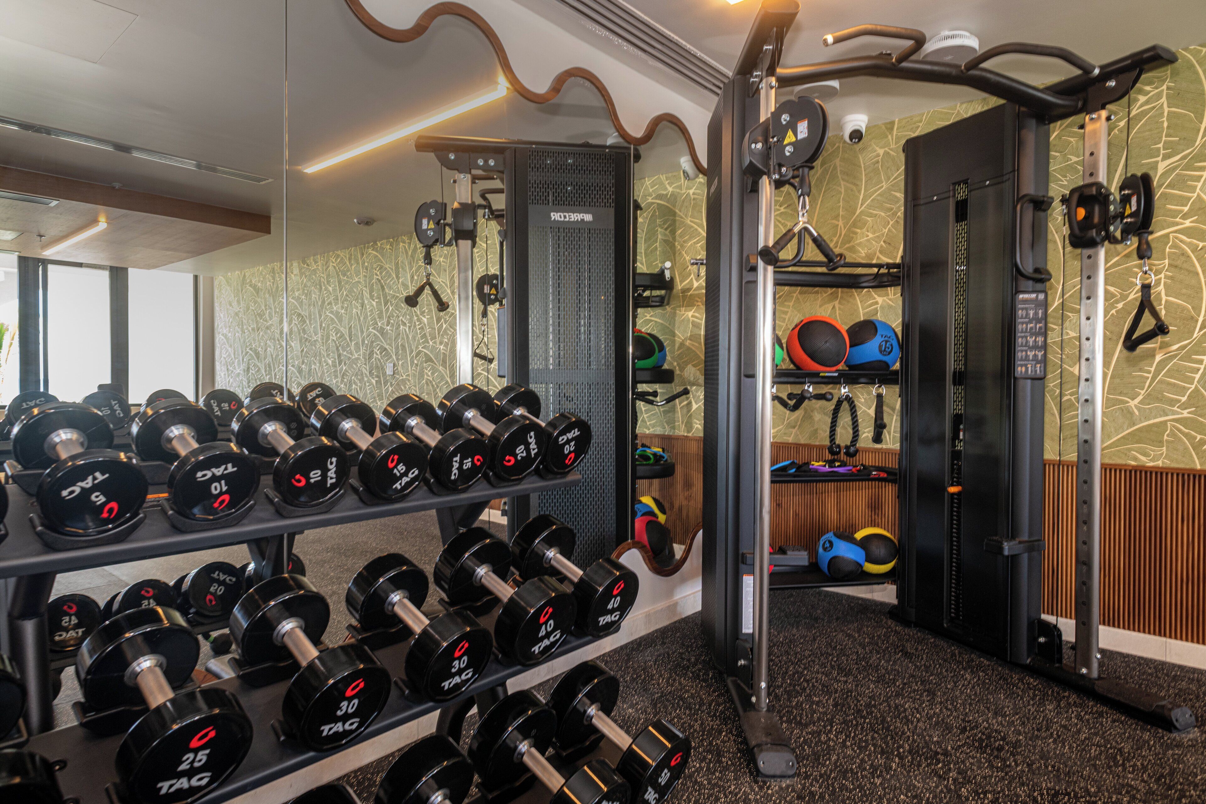 A gym with weight racks, dumbbells, and exercise equipment.