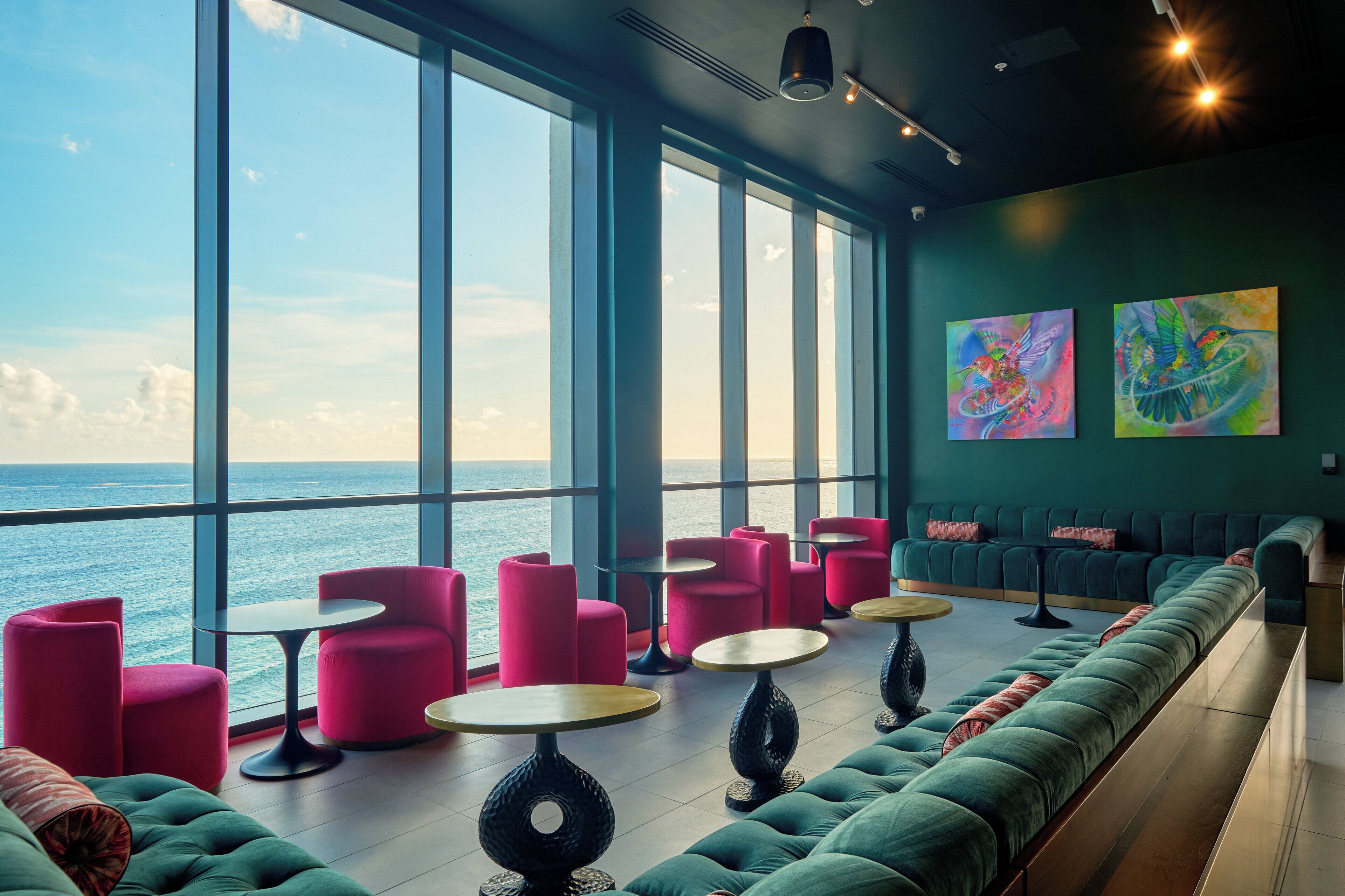 Eine moderne Lounge mit großen Fenstern, Sitzbereichen und Kunstwerken.
