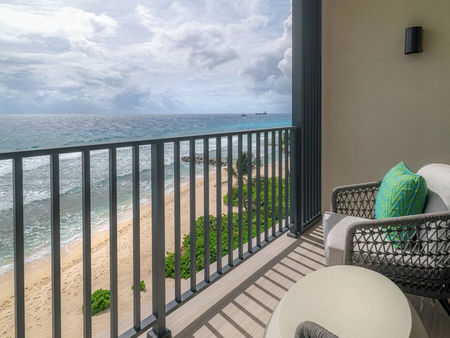 A balcony with a view of a beach and ocean.