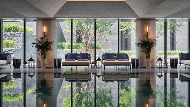 A modern lobby with a reflective floor, large windows, and a central seating area with sofas and potted plants. - Intercontinental Changchun High Tech Zone by IHG (Changchun)