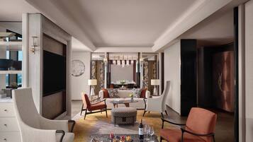 A modern hotel room with a dining area, a flat-screen TV, and a large window.