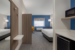 A hotel room with two beds, a desk, a chair, a microwave, and a window with blinds. - Holiday Inn Express And Suites Huntsville Northeast by IHG (Huntsville)