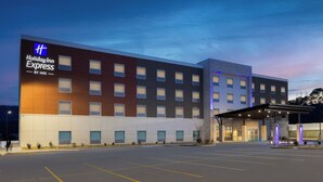 A Holiday Inn Express building with a modern design, large windows, and a covered entrance area. - Holiday Inn Express And Suites Huntsville Northeast by IHG (Huntsville)