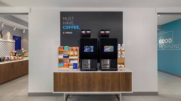 A coffee station with two espresso machines, a sign that says 'MUST. HAVE. COFFEE. EXPRESS,' and a 'GOOD MORNING' sign on the wall.