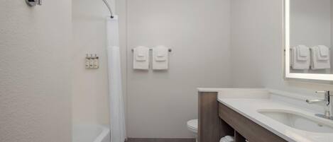 A modern bathroom with a bathtub, a toilet, and a sink.