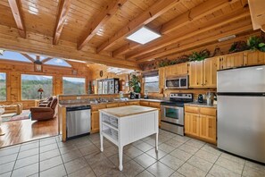 A spacious kitchen with wooden cabinets, a central island, and a large refrigerator.
