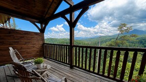 Eine Holzterrasse mit Blick auf eine gebirgige Landschaft.