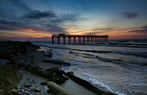 A pier extending into the ocean at sunset.