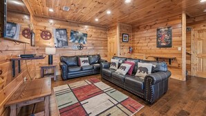 A wooden interior with a sofa, a rug, and wall decorations.