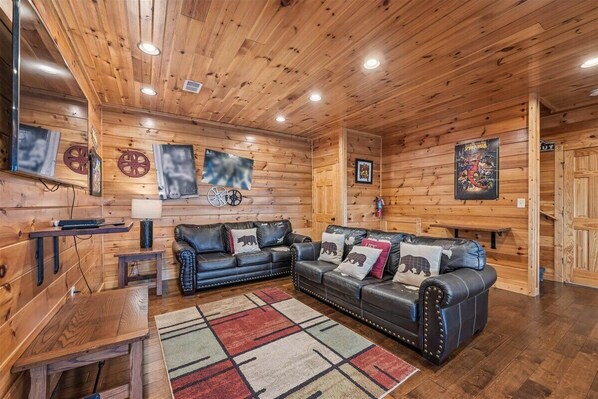 A wooden interior with a sofa, a rug, and wall decorations.