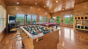 A wooden-floored room with a foosball table, pool table, and a bar area. - Relaxing Smoky Mtn. Getaway w/Views & Family Fun! (Gatlinburg)