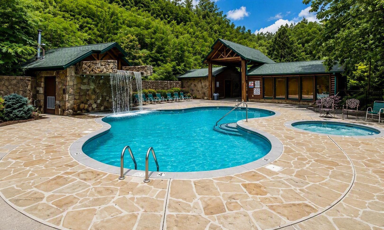 Ein Poolbereich mit zwei Whirlpools, einer Wasserfallanlage und Steinplattenböden.