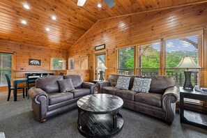 Un intérieur en bois comprenant un ensemble de canapés, une table basse ronde et un coin repas.