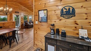 Un interior de madera con comedor, estación de café y un letrero que dice 'Welcome'.