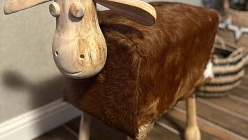 Una escultura de madera de oveja con cuerpo marrón y cabeza y patas de madera clara.