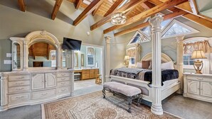 A spacious bedroom with a large bed, a vanity with a mirror, and a desk. - Elegant Mountain Vista w/ Games & Hot Tub (Sevierville)