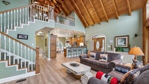 A spacious living area with a staircase, a dining area, and a kitchen. - Elegant Mountain Vista w/ Games & Hot Tub (Sevierville)
