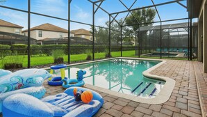 A swimming pool with inflatable toys and a brick patio. - The Moon Valley Oasis - Spacious 7-bedroom house with Pool, and Game room. (Four Corners)