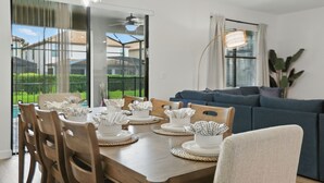 A dining area with a wooden table set for four, surrounded by chairs. - The Moon Valley Oasis - Spacious 7-bedroom house with Pool, and Game room. (Four Corners)
