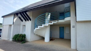 Ein zweistöckiges Gebäude mit einer Wendeltreppe, die zum Obergeschoss führt.
