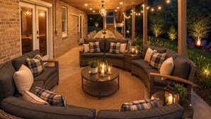 A covered outdoor patio with a dining area, seating arrangements, and ambient lighting.