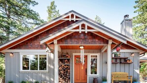 A rustic cabin with a wooden exterior, a front porch, and a chimney.