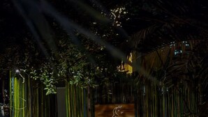Une porte en bois, sur laquelle est apposée une pancarte indiquant « K'U'KUK GLAMPING », mène à un escalier.