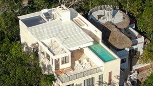 Une maison moderne avec un toit plat, de grandes fenêtres et une piscine.