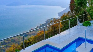 A swimming pool with a view of a body of water and hills. - Stunning Lake-view Villa at Coatepeque - Wifi, A/C (El Congo)