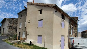 Un edificio de dos pisos con fachada de piedra y techo plano.