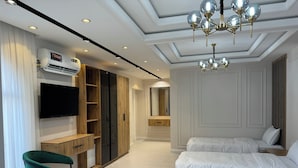 A modern bedroom with a large bed, a TV, a wardrobe, and a desk. - Astoria Boutique hotel & SPA (Samarkand)