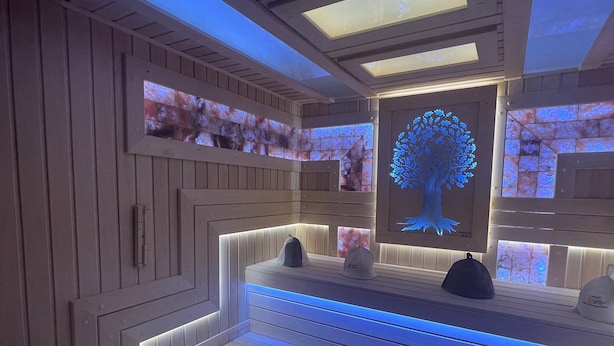 A modern spa room with wooden paneling, a central bench, and a digital tree display. - Astoria Boutique hotel & SPA (Samarkand)