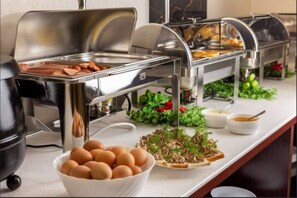 Un aparador de buffet amb diversos aliments, com ara ous, pa i salses.