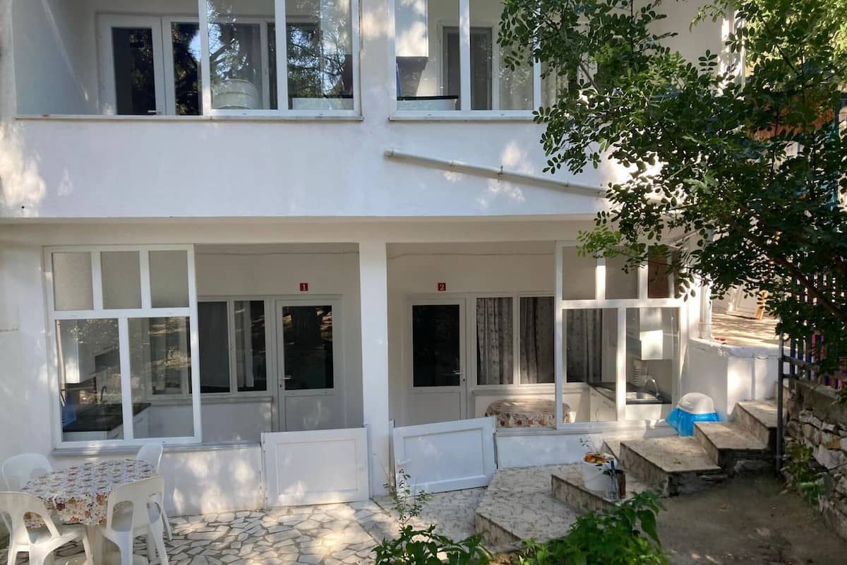 A two-story building with a covered patio area, white exterior walls, and large windows.