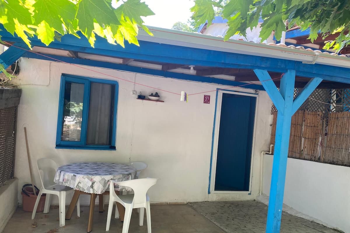 A small, enclosed patio area with a table and chairs, a door, and a window.