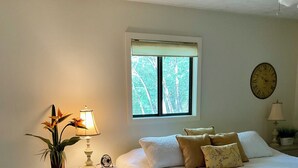 A bedroom with a bed, bedside tables, a chair, a window, and a wall clock. - Cozy 3bedroom home w AC, WiFi, in a golf retreat, nestled in the scenic mountain (Basye)