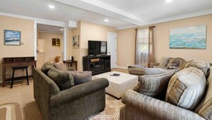 Una sala de estar con un conjunto de sofá, una televisión y una mesa de centro.