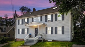 A two-story house with a front porch, a staircase, and a small front yard.
