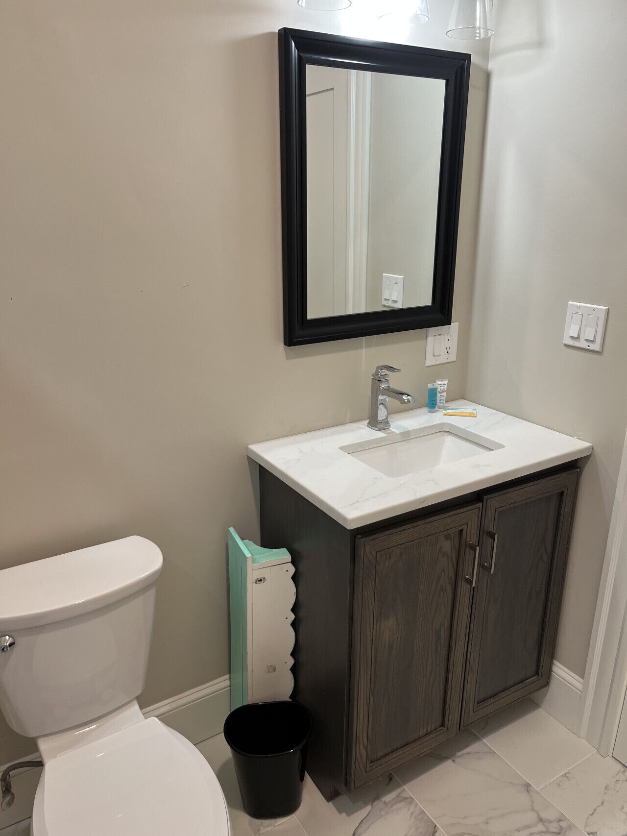Une salle de bain avec des toilettes, un lavabo et un miroir.