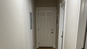 A hallway with wooden flooring and white walls. - Dwtn Apt~King Beds~Mins to Salem (Beverly)