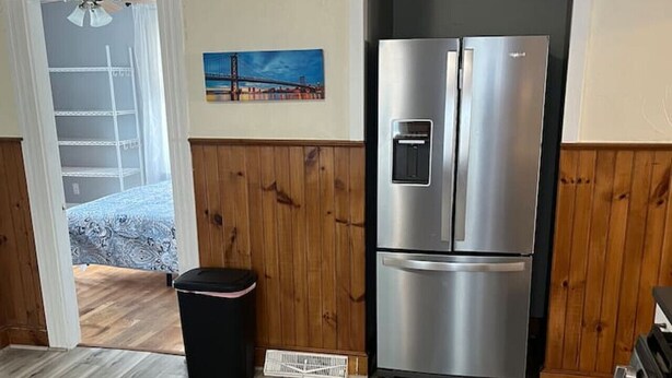 A kitchen with wooden paneling, a stainless steel refrigerator, and a wooden floor. - Beverly/Salem! Dwtn/Water/Train (Beverly)