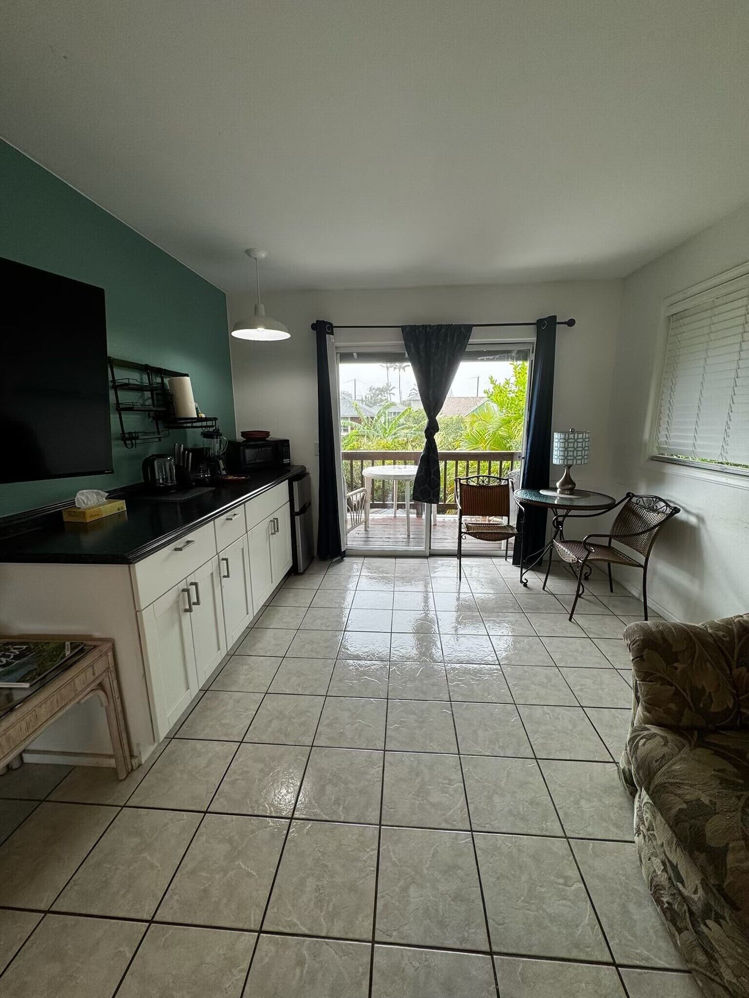 A kitchen with a dining area, a TV, and a view of the outdoors.