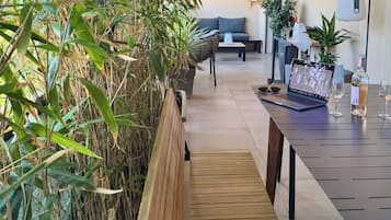 Ein modernes Interieur mit einer Holzbänkl, einem Esstisch mit Weingläsern und einem Laptop.