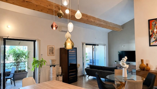 Una sala de estar moderna con un sofá, un televisor y un comedor con una mesa y sillas.