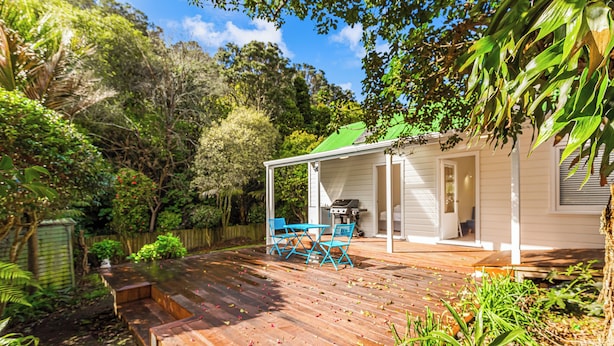 A wooden deck with a covered patio area, a barbecue grill, and a small table and chairs. - Serene 2BR Home w Grill & Yard by Zodiak Stays (Auckland)