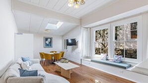 Un salon comprenant un canapé, une table basse et un coin repas avec des chaises.