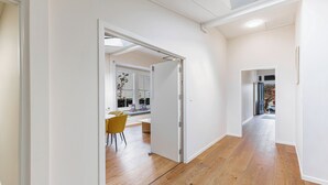 Un intérieur moderne avec un plancher en bois, des murs blancs et un coin repas doté de chaises jaunes.