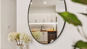 A modern kitchen with white cabinets, a herringbone backsplash, and a dishwasher. - Stunning 1BR Apt in Heritage Hotel by Zodiak Stays (Auckland)