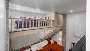 Une pièce à plusieurs niveaux avec un lit superposé et un canapé.